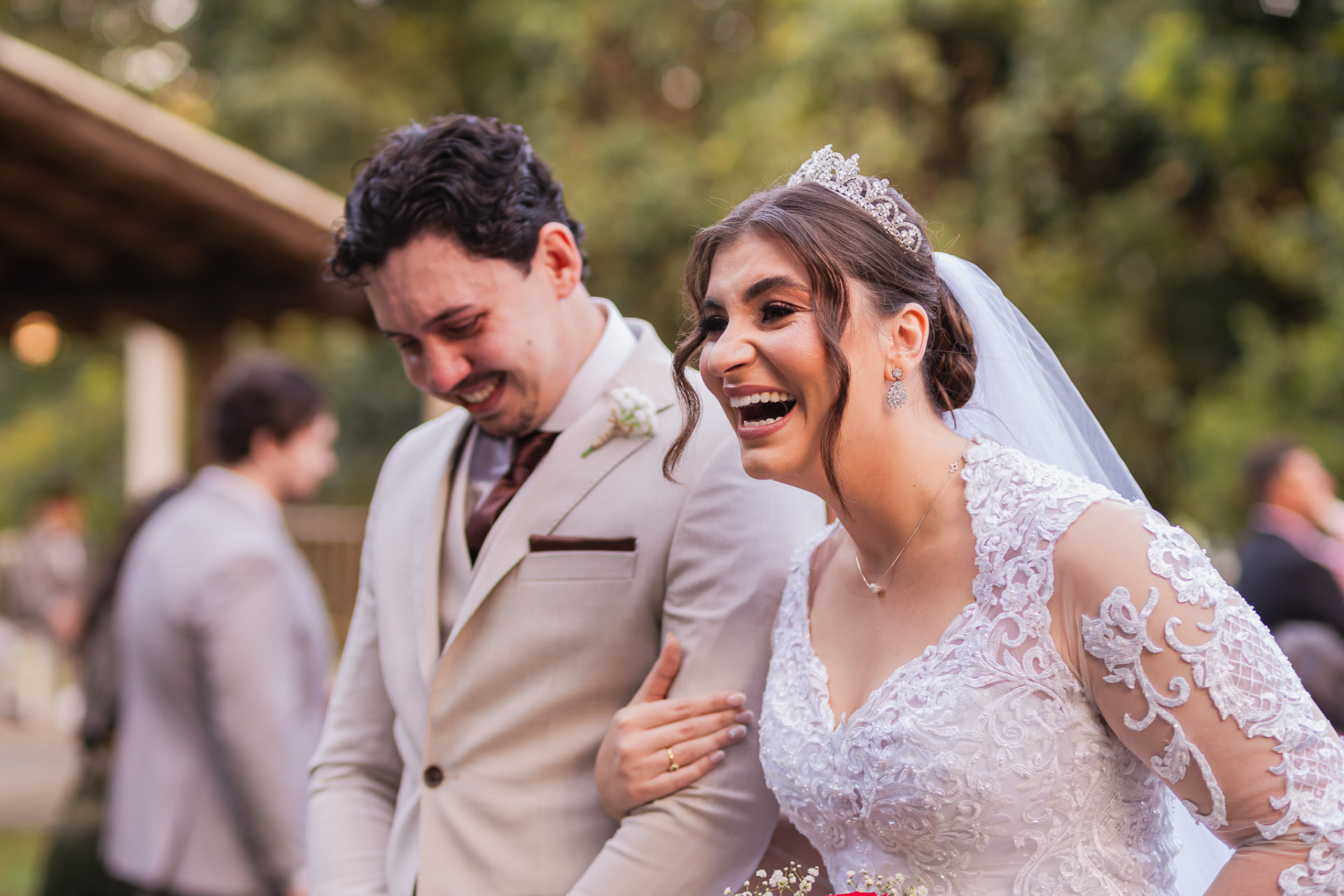 Casal de noivos rindo juntos após a cerimônia de casamento no campo
